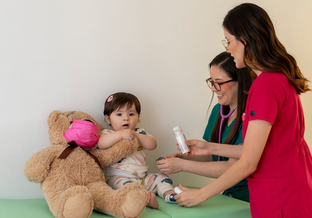 Child with doctors and teddy bear.
